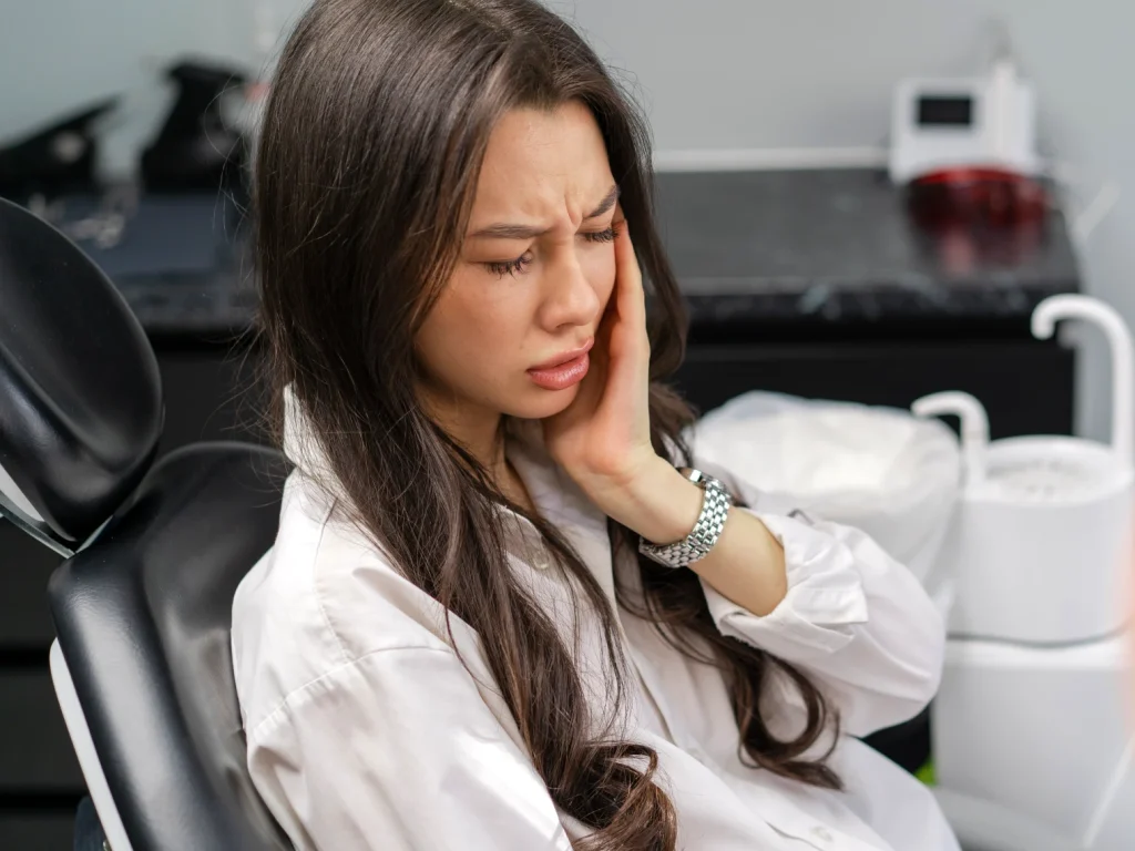 Young woman at the dentist experiencing tooth pain | Emergency dentist in Edmond, OK